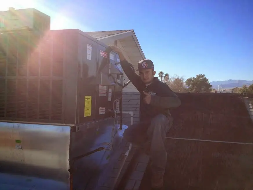 HVAC technician performing HVAC Inspection on a rooftop unit in Matteson