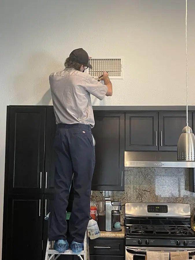 Technician inspecting an air vent during HVAC service in Matteson
